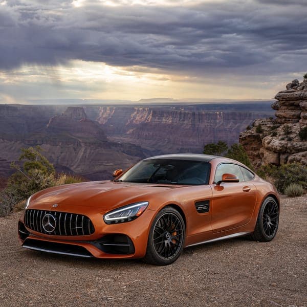 Mercedes-AMG GT jigsaw puzzle — An orange Mercedes-AMG GT at a canyon overlook under a breaking sky.