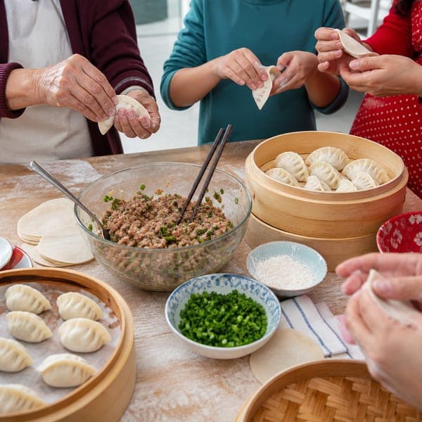 Dumpling Day jigsaw puzzle — Three generations pleating dumplings around a flour-dusted table.
